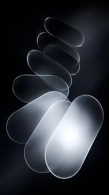 Floating stack of frosted translucent oval glass capsules creating a monochrome spiral design against a dark backdrop.