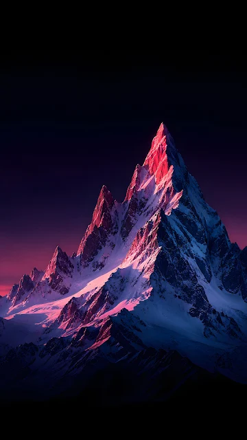 A sharp, snow-dusted black mountain peak illuminated by deep pink twilight against a dark, star-filled upper sky.