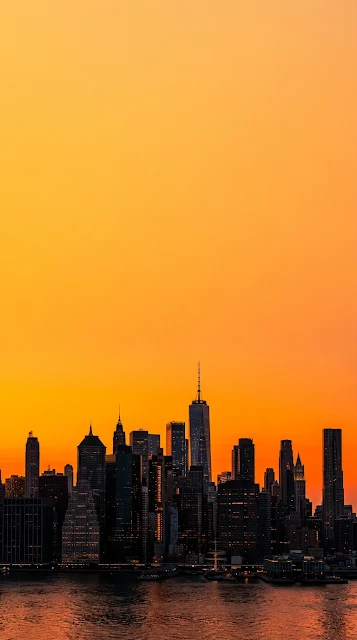Dramatic Orange Sunset Silhouette over New York City Skyline - Free 4K & 8K mobile Wallpaper
