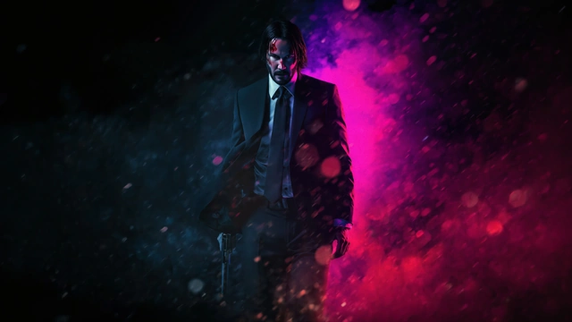 John Wick in a black suit walking forward through heavy rain illuminated by neon pink and cyan blue lights.