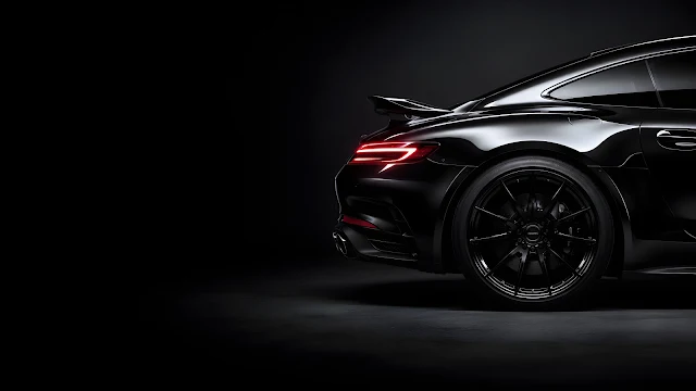 Glossy black high-end sports car rear quarter panel showcasing curved bodywork and a sleek red light bar against a dark gray backdrop.