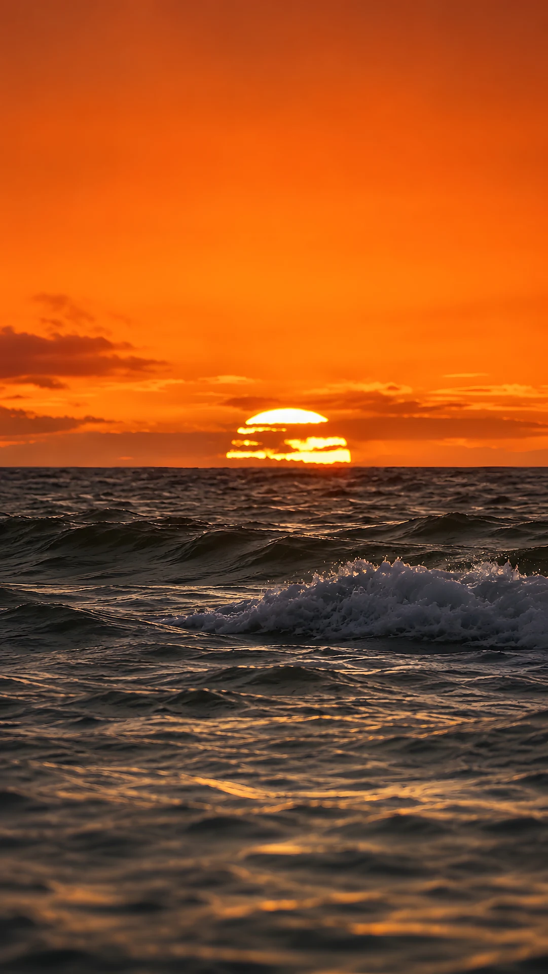 Rolling ocean waves under a dramatic orange sunset sky - Free 4K mobile Wallpaper