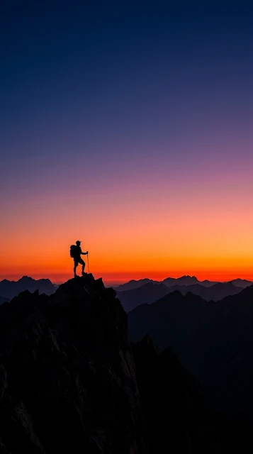 Silhouette of a Lone Hiker on a Peak Against Fiery Red Dawn Sky - Free 4K & 8K mobile Wallpaper
