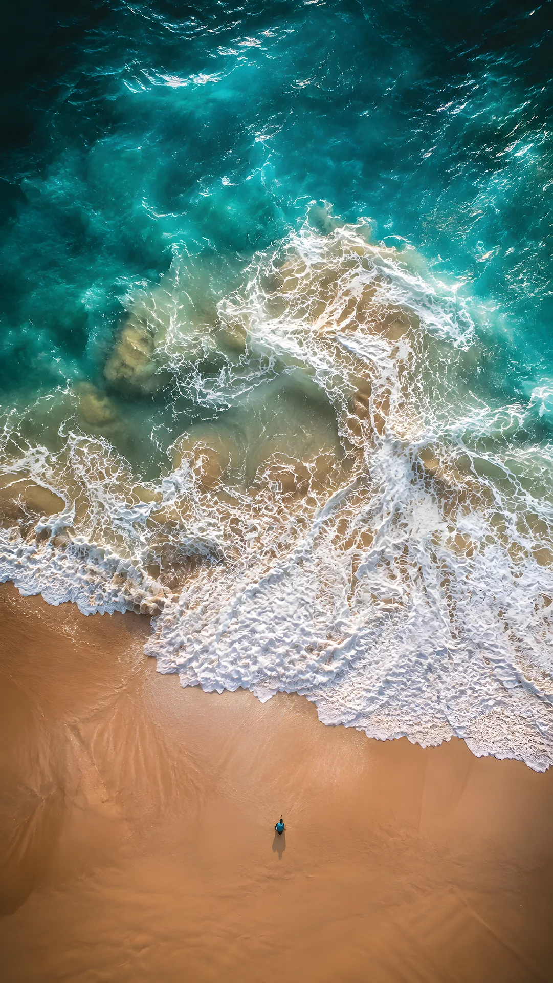 Top-down aerial view of turquoise ocean waves crashing on sandy beach - Free 4K mobile Wallpaper