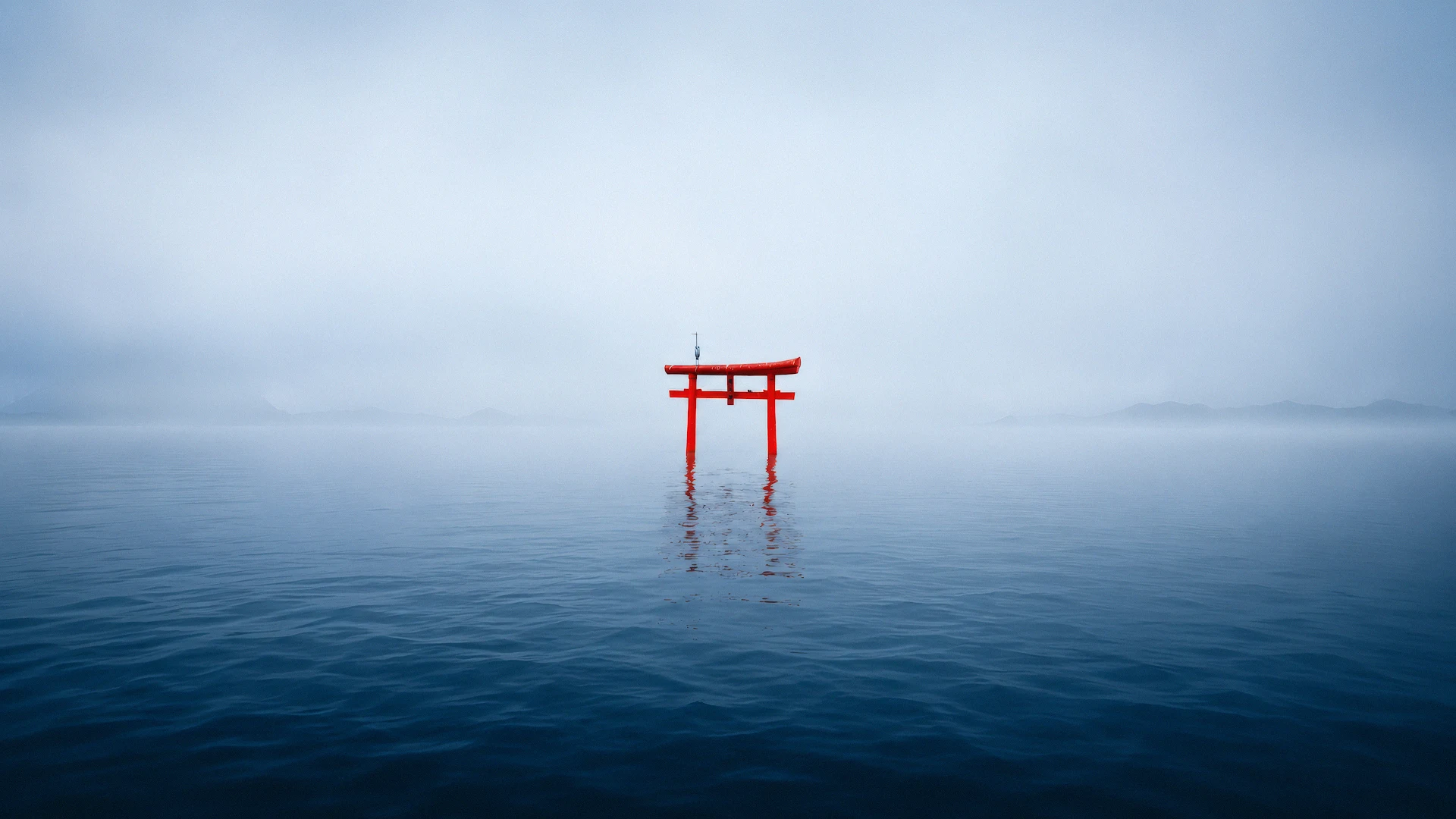 Traditional red torii gate standing in calm misty lake waters - Free 4K desktop Wallpaper