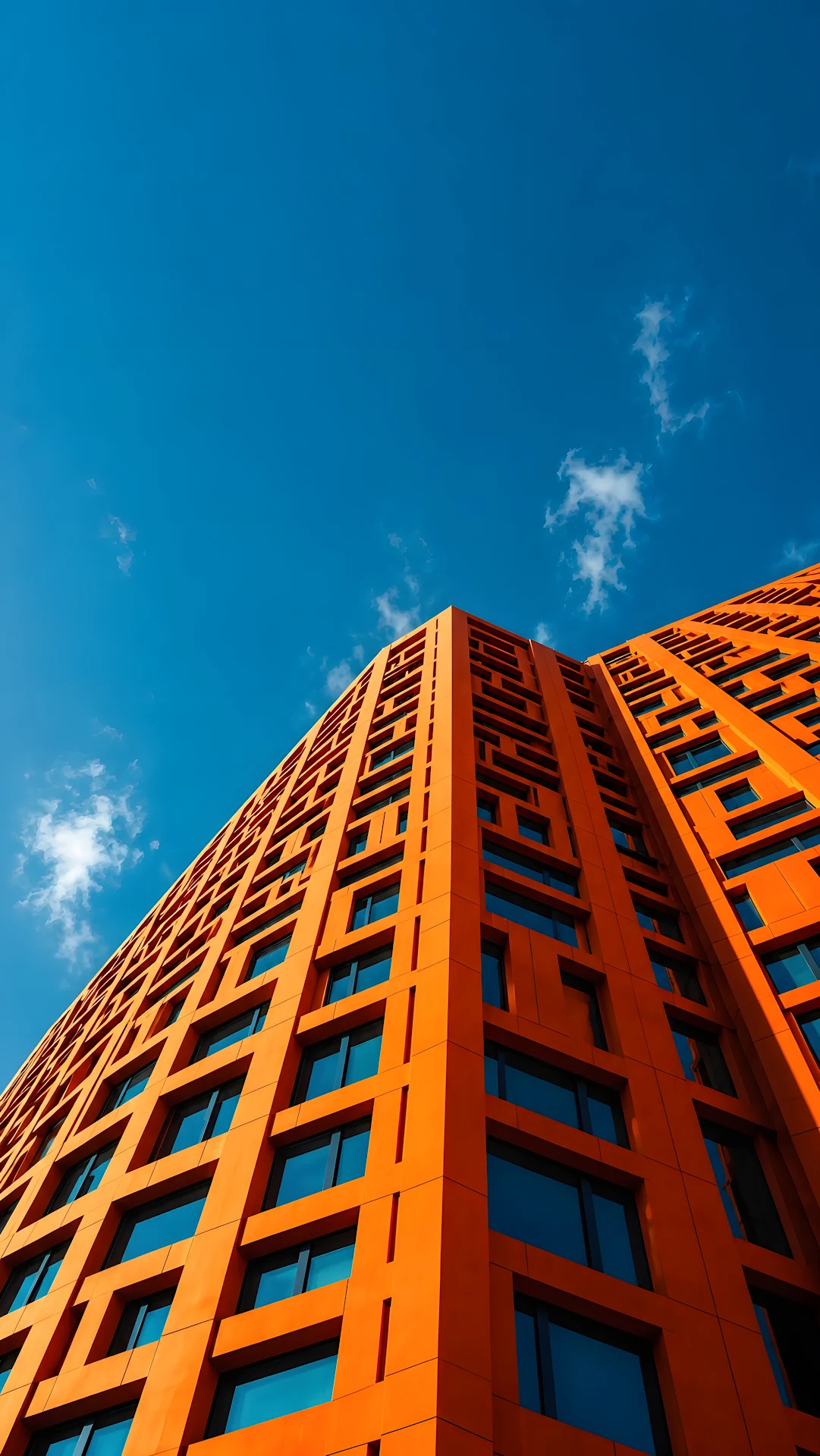 Vibrant orange modern building perspective against clear blue sky - Free 4K mobile Wallpaper